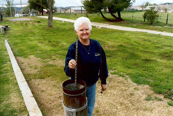 Ms. Arvilla Johnson measuring precipitation gage in Campo, California, March 5, 2005.